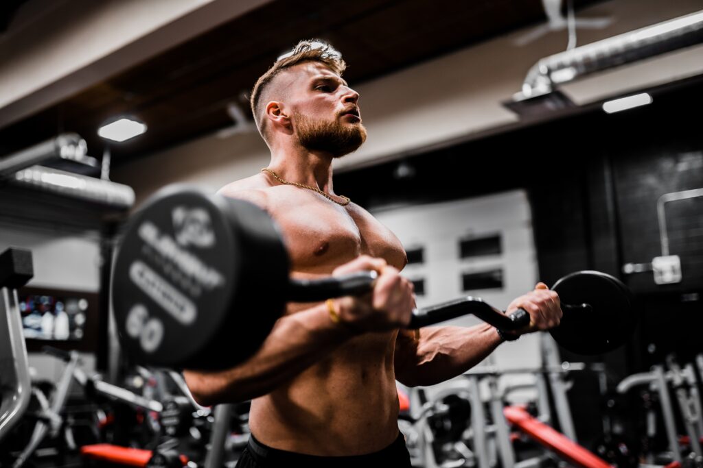 homme qui fait du curl biceps à la barre